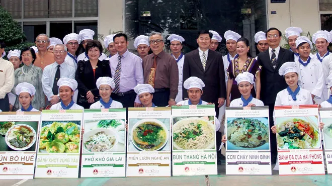 Students of Saigontourist Hospitality College with images of the 12 Vietnamese dishes achieving the Asian Record at the announcement ceremony on the morning of Sept 7th. Photo: Vietkings - tuoitre.vn