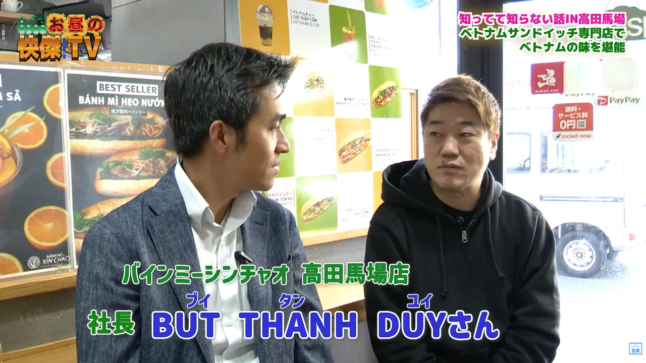 バインミーシンチャオの共同創業者であるブイ・タン・ユイが、MCの魔耶一星さんにブランドの成長ストーリーを語る様子。 出典：番組公式動画よりスクリーンショット